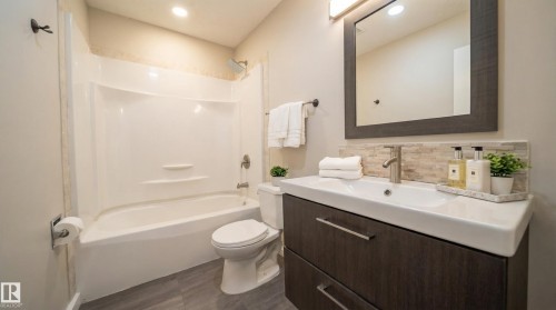 Bathroom featuring shower / washtub combination, vanity, dark wood-style flooring, backsplash, and recessed lighting - 2311 146 Avenue, Edmonton, AB - Indoor Photo Showing Bathroom