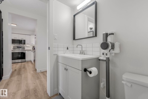 This bathroom features a contemporary vanity with a rectangular sink, a square mirror, and white subway tile backsplash - 33 4403 Riverbend Road, Edmonton, AB - Indoor Photo Showing Bathroom