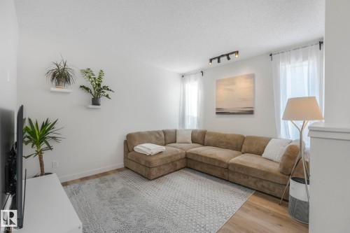 Living area featuring light wood flooring, a textured area rug, and track lighting - 33 4403 Riverbend Road, Edmonton, AB - Indoor Photo Showing Living Room