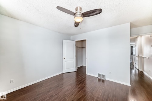 Room featuring dark hardwood flooring, light-colored walls, and a ceiling fan with an integrated light fixture - 1911 36 Avenue, Edmonton, AB - Indoor