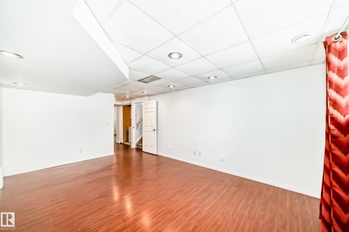 Spacious room featuring rich hardwood flooring, recessed lighting, and a white drop ceiling - 1911 36 Avenue, Edmonton, AB - Indoor Photo Showing Other Room