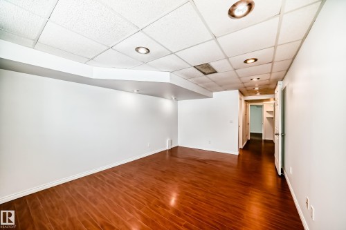 Spacious room featuring rich hardwood flooring, crisp white walls, and recessed lighting - 1911 36 Avenue, Edmonton, AB - Indoor Photo Showing Other Room