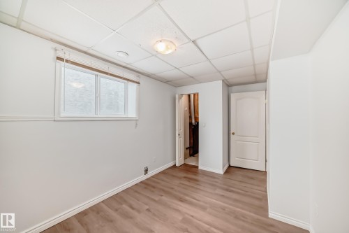 Room featuring light wood-style flooring, a window with blinds, and white walls - 1911 36 Avenue, Edmonton, AB - Indoor Photo Showing Other Room