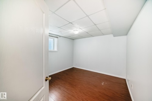 This room features wood flooring, light-colored walls, and a window providing natural light - 1911 36 Avenue, Edmonton, AB - Indoor Photo Showing Other Room