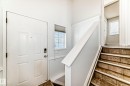 Entryway featuring a white paneled door with a smart lock, a window with blinds, and tiled stairs with white trim - 1911 36 Avenue, Edmonton, AB  - Indoor Photo Showing Other Room 