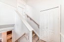 Interior staircase with light-toned handrails, tiled steps, and white bi-fold doors - 1911 36 Avenue, Edmonton, AB  - Indoor Photo Showing Other Room 