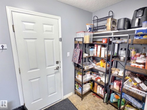 The property features a white paneled door with a contemporary handle, set against light gray walls - 14 6608 158 Avenue, Edmonton, AB - Indoor Photo Showing Other Room