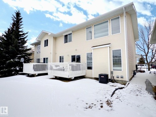 The property features a light-colored exterior siding, multiple windows, and two private decks - 14 6608 158 Avenue, Edmonton, AB - Outdoor With Exterior