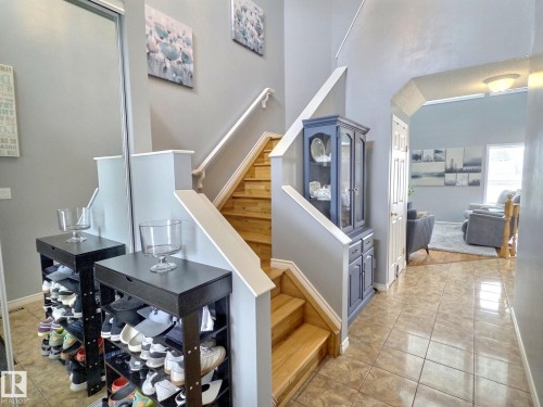 The property features a staircase with light wood treads and white risers, complemented by white handrails - 14 6608 158 Avenue, Edmonton, AB - Indoor Photo Showing Other Room