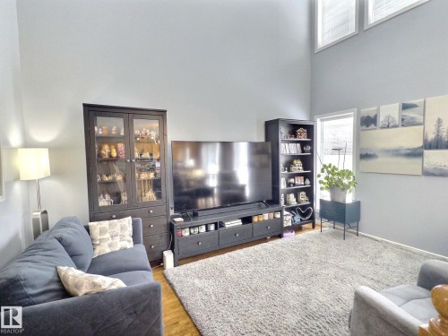 Living area featuring light-colored walls, a large area rug, and hardwood flooring - 14 6608 158 Avenue, Edmonton, AB - Indoor Photo Showing Living Room