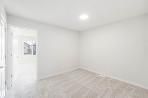This room features light-colored carpeting, white walls, and a circular ceiling light fixture - 18940 28 Avenue, Edmonton, AB - Indoor Photo Showing Other Room