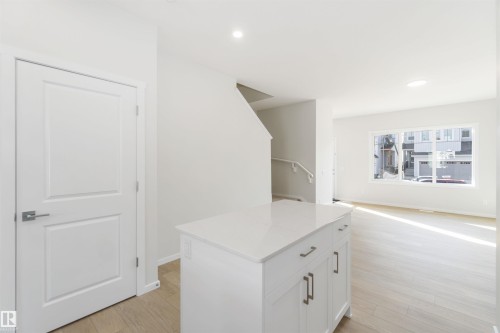 Bright living area with light wood flooring, white walls, and a large window - 18940 28 Avenue, Edmonton, AB - Indoor Photo Showing Other Room