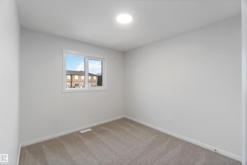This room features light grey walls, grey carpet flooring, and a single window allowing for natural light - 5452 Hawthorn Run, Edmonton, AB - Indoor Photo Showing Other Room