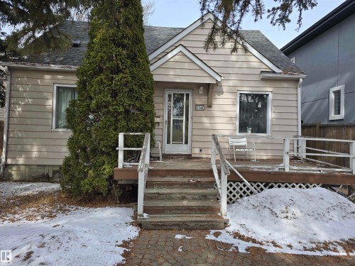 The property features a front porch with a wooden deck and railing, complemented by a paved walkway leading to the entrance - 8146 78 Avenue Nw, Edmonton, AB - Outdoor