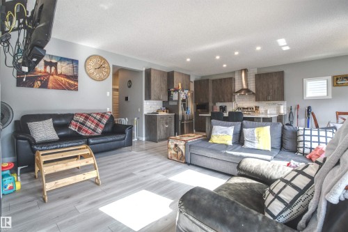 The living space features light-colored flooring and recessed lighting, with an open layout that incorporates the kitchen - 20503 99 Avenue, Edmonton, AB - Indoor Photo Showing Living Room