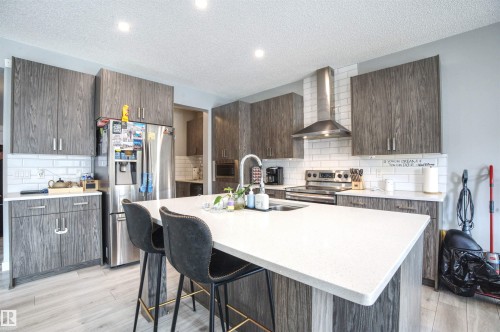 The kitchen features grey wood grain cabinetry, white subway tile backsplash, and light-colored countertops - 20503 99 Avenue, Edmonton, AB - Indoor Photo Showing Kitchen With Double Sink With Upgraded Kitchen