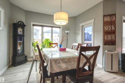 This dining area features light-colored walls, a prominent window, and light wood flooring - 20503 99 Avenue, Edmonton, AB - Indoor Photo Showing Dining Room