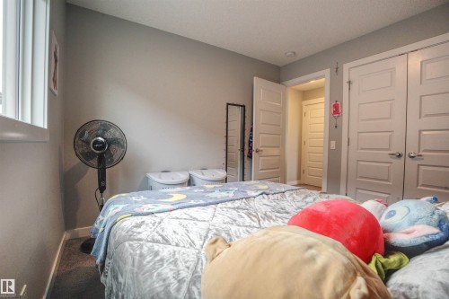 This room features neutral gray walls, a window with white trim, and light-colored interior doors - 20503 99 Avenue, Edmonton, AB - Indoor Photo Showing Bedroom