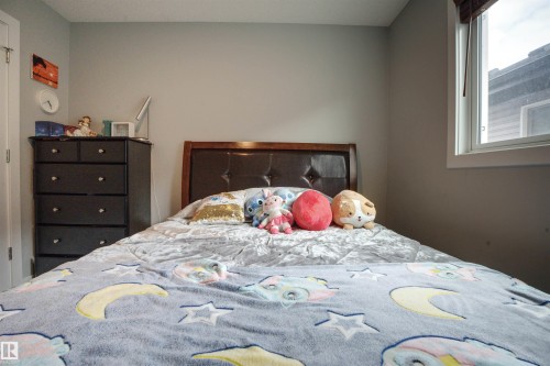 This room features a window with blinds, a dark wood headboard, and a dark-colored dresser with five drawers - 20503 99 Avenue, Edmonton, AB - Indoor Photo Showing Bedroom