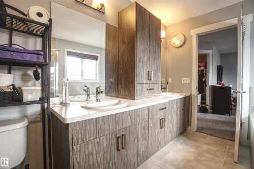 Well-appointed bathroom featuring a double vanity with ample cabinetry, a white countertop, and dual sinks - 20503 99 Avenue, Edmonton, AB - Indoor Photo Showing Bathroom