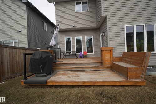 The property features a wood deck with an integrated wooden bench, providing direct access to the interior through a set of glass doors - 20503 99 Avenue, Edmonton, AB - Outdoor With Deck Patio Veranda With Exterior