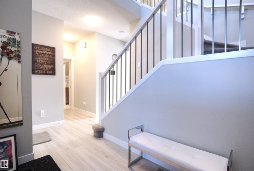 Entryway featuring light wood-style flooring and a staircase with white risers and dark balusters - 20503 99 Avenue, Edmonton, AB - Indoor Photo Showing Other Room