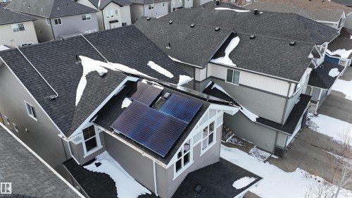 Overhead view of the property showcasing a dark shingle roof, light grey siding with white trim, and solar panels installed on a section of the roof - 20503 99 Avenue, Edmonton, AB - Outdoor
