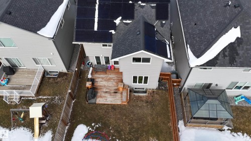 The property features a spacious backyard with a deck and a green house structure - 20503 99 Avenue, Edmonton, AB - Outdoor