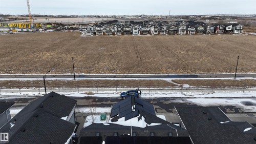 Aerial view of the property's roof with solar panels, facing a paved road and a large open field - 20503 99 Avenue, Edmonton, AB - Outdoor With View