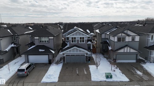 The property features a two-story exterior with a gray and white facade and a dark roof - 20503 99 Avenue, Edmonton, AB - Outdoor With Facade
