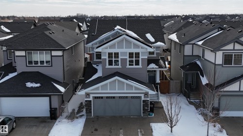 Well-maintained property featuring a gray exterior with white trim, a dark gray roof, and an attached garage with a dark gray door - 20503 99 Avenue, Edmonton, AB - Outdoor With Facade