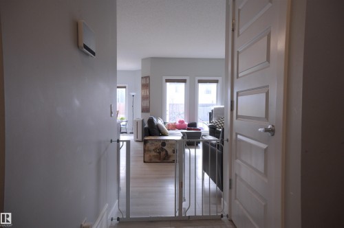 The living area features light-colored walls and flooring, with natural light entering through windows - 20503 99 Avenue, Edmonton, AB - Indoor Photo Showing Other Room