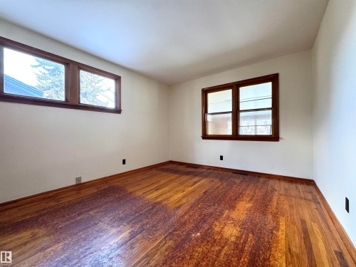This room features hardwood floors and two windows with wooden frames - 12219 48 Street, Edmonton, AB - Indoor Photo Showing Other Room