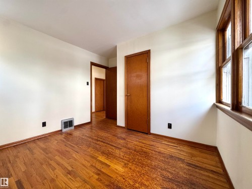 Room featuring hardwood floors, warm white walls, and a multi-pane window with wood trim - 12219 48 Street, Edmonton, AB - Indoor Photo Showing Other Room
