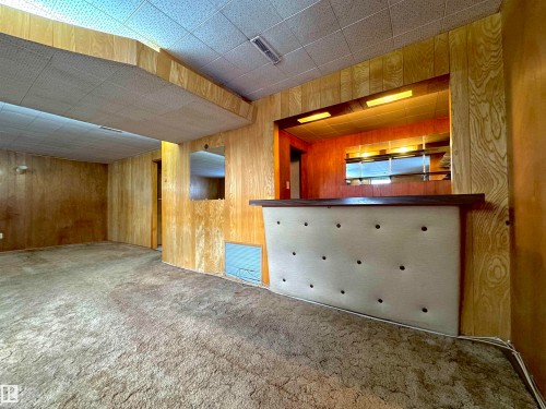 This room features paneled walls, a drop ceiling, and carpeted flooring - 12219 48 Street, Edmonton, AB - Indoor Photo Showing Other Room