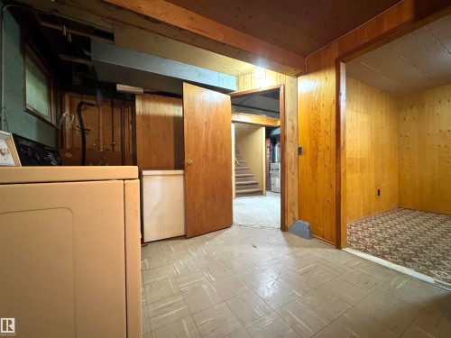 This property features wood paneling, wood beam ceilings, and a light-colored tile floor - 12219 48 Street, Edmonton, AB - Indoor
