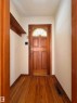 Entryway featuring a wooden door with a glass panel, light-colored walls, and hardwood flooring - 12219 48 Street, Edmonton, AB  - Indoor Photo Showing Other Room 