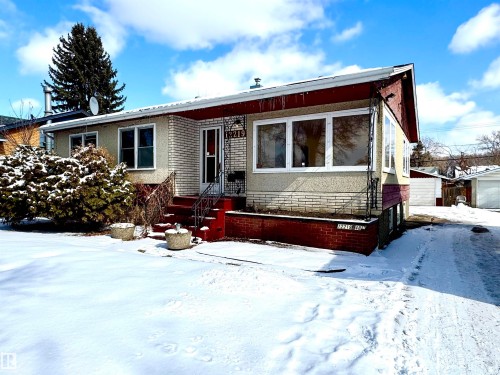 The property features a brick exterior with a front entrance, a front yard, and a driveway - 12219 48 Street, Edmonton, AB - Outdoor