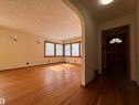 The property features hardwood floors, a bay window, and a wood door with an arched window - 12219 48 Street, Edmonton, AB  - Indoor Photo Showing Other Room 