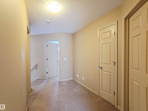 The interior features light-colored carpeting and walls, along with paneled doors and trim - 60 1128 156 Street, Edmonton, AB - Indoor Photo Showing Other Room