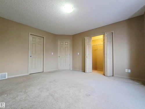 The room features neutral-toned walls, carpeted flooring, and a ceiling light fixture - 60 1128 156 Street, Edmonton, AB - Indoor Photo Showing Other Room