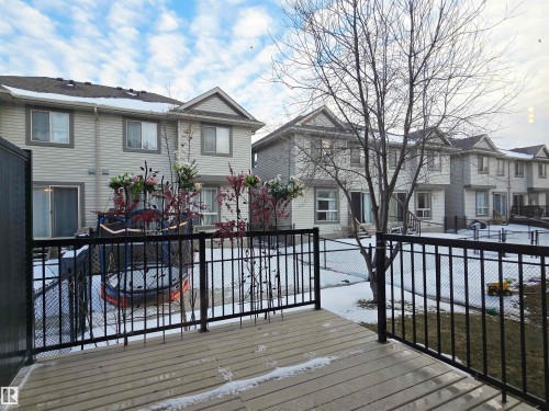 The property features a private deck with a black metal railing, overlooking a fenced yard - 60 1128 156 Street, Edmonton, AB - Outdoor With Deck Patio Veranda