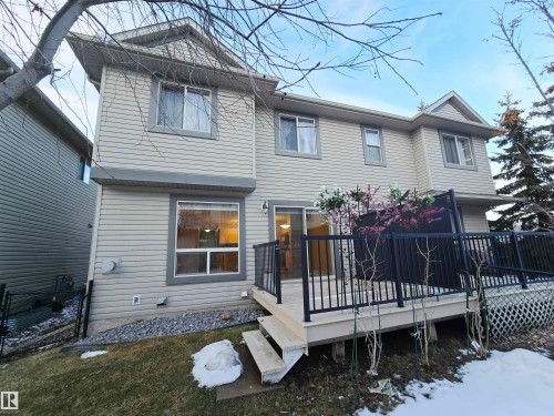 The property features a private deck with black railings, accessible via a sliding glass door, and a ground-level window - 60 1128 156 Street, Edmonton, AB - Outdoor With Deck Patio Veranda With Exterior