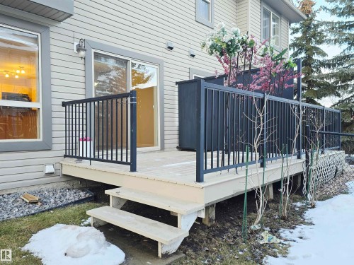 The property features a spacious rear deck with black metal railings and two steps leading down to the yard - 60 1128 156 Street, Edmonton, AB - Outdoor With Deck Patio Veranda With Exterior