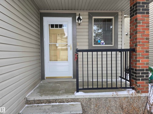 The property features a concrete porch with steps, a white storm door, and light-colored siding - 60 1128 156 Street, Edmonton, AB - Outdoor With Exterior