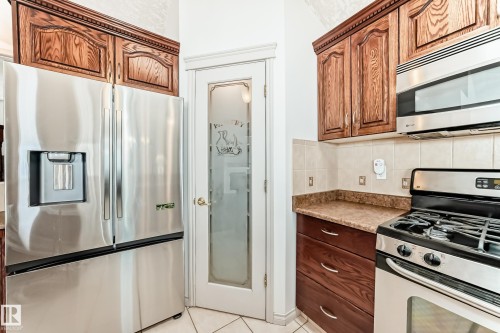 The kitchen features stainless steel appliances including a refrigerator, microwave, and range - 10631 181 Avenue, Edmonton, AB - Indoor Photo Showing Kitchen