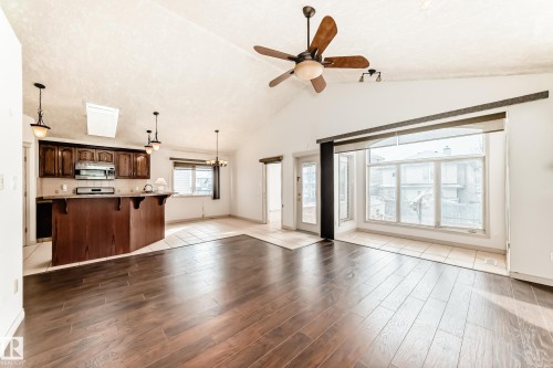 Open-concept living area with dark wood flooring, vaulted ceilings, and a ceiling fan - 10631 181 Avenue, Edmonton, AB - Indoor