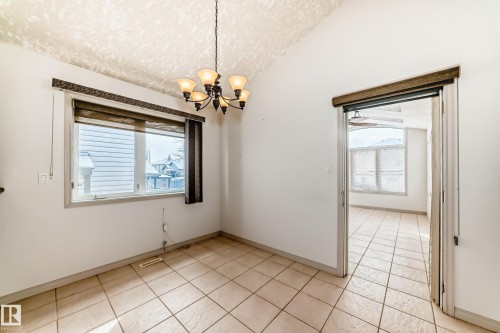 This room features a vaulted ceiling, a hanging chandelier light fixture, and tile flooring - 10631 181 Avenue, Edmonton, AB - Indoor Photo Showing Other Room