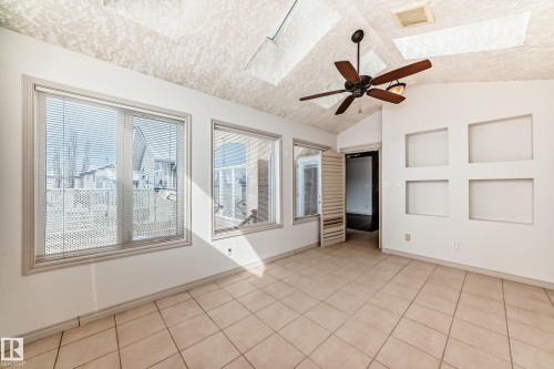 Spacious room featuring vaulted ceilings, a ceiling fan with integrated lighting, tiled flooring, and multiple windows with blinds - 10631 181 Avenue, Edmonton, AB - Indoor Photo Showing Other Room