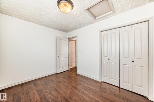 This room features rich, dark wood flooring, white walls, and a white bi-fold closet - 10631 181 Avenue, Edmonton, AB - Indoor Photo Showing Other Room